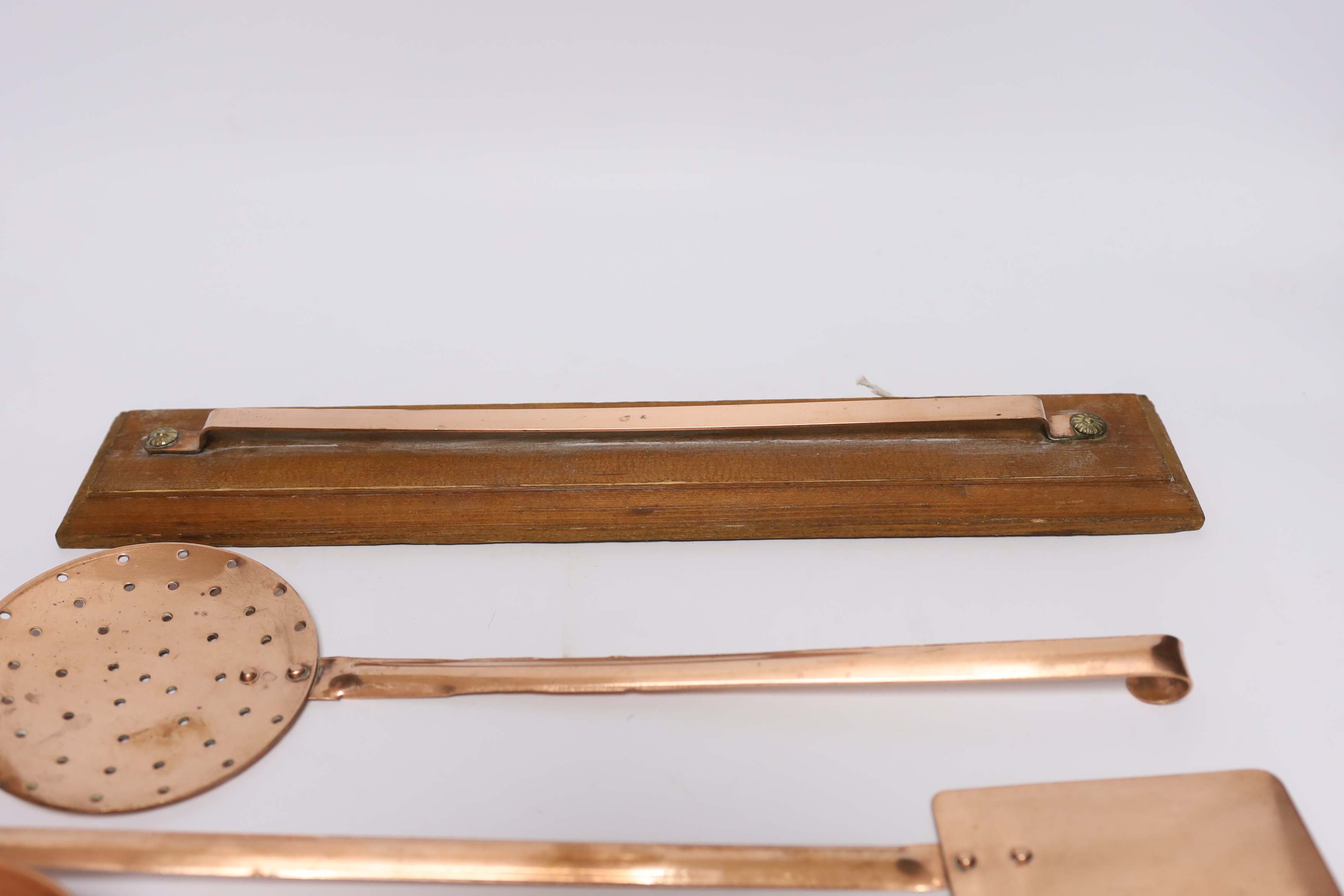 A set of five French copper utensils with hanging rack